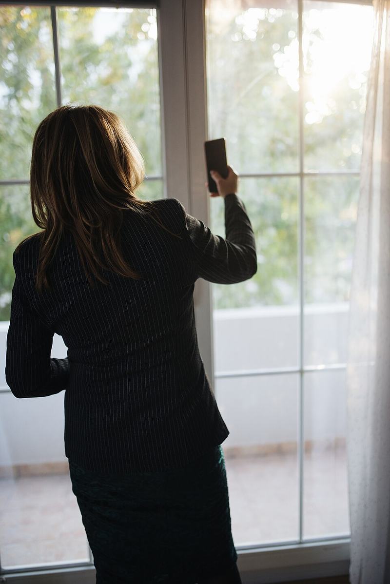 Cuidadora ayudando a un hombre mayor a levantarse del sillón en el salón de su casa